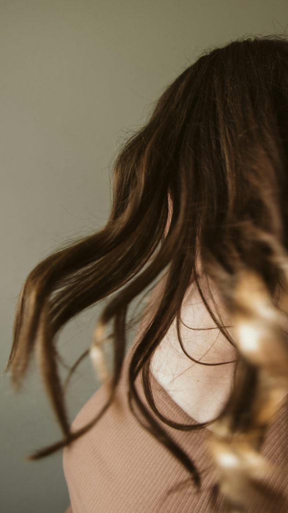 Hair caught mid-motion, warm light on the lengths.